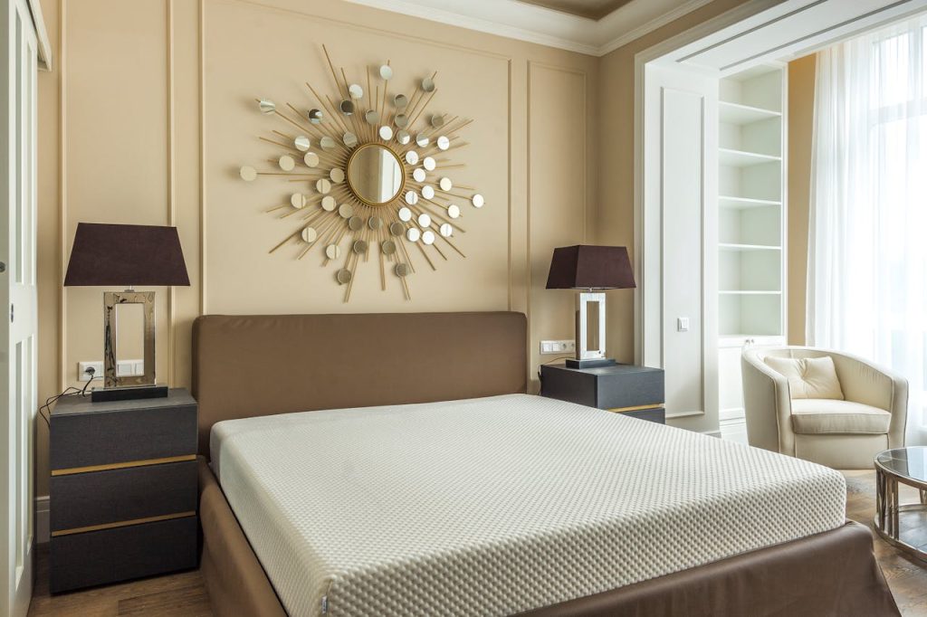 Elegant modern bedroom featuring minimalist design with unique mirror art above the bed.